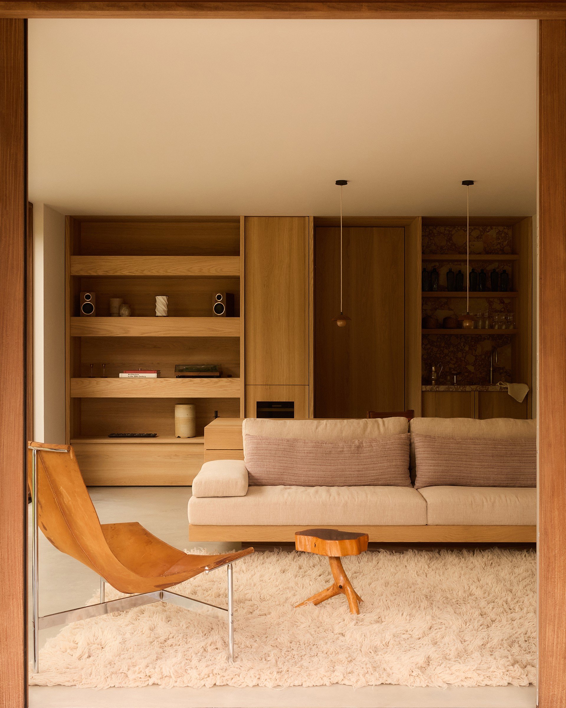 Garden room lounge with vintage chairs and bespoke shelving